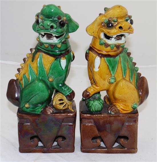 A pair of Chinese sancai glazed figures of Buddhist lions seated on plinths, 19th/20th century, 25cm